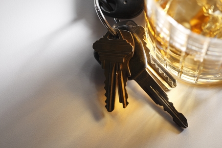 keys next to a glass of alcohol